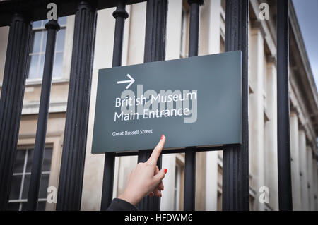 Young Woman pointing at British Museum Entrée principale sign Banque D'Images