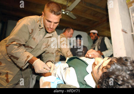 040511-A-0000M-001 Konar Province, l'Afghanistan (11 mai 2004) - U.S. Navy Hospital Corpsman 3 classe Chris ose s'occupe d'un jeune homme afghan avec des pierres de rein qui sont venus à la clinique médicale des Forces spéciales dans la province de Konar. La clinique est située à une force un camp et traite plus de 150 patients par jour. Corpsman Hôpital de la marine travaillent côte à côte avec les forces spéciales de l'Armée américaine à un camp comme celui-ci répartis dans tout l'Afghanistan. L'Armée américaine photo par le Sgt. Frank Magni. (Libéré) US Navy 040511-A-0000M-001 U.S. Navy Hospital Corpsman 3 classe Chris ose s'occupe d'une Banque D'Images