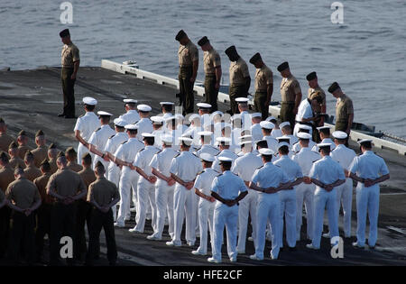 040718-N-0535P-029 de l'Océan Atlantique (18 juillet 2004) - marins et Marines baissent la tête en ce qui a trait au cours d'une cérémonie de dépôt de gerbes eu lieu sur le pont d'envol en l'honneur du Capitaine Franklin hameçons II, attribué à l'ÒSilver EaglesÓ des Fighter Attack Squadron One One cinq (VMFA-115). Hooks est mort lorsque son F/A-18 Hornet jet s'est écrasé lors d'effectuer des exercices sur le porte-avions USS Harry S. Truman, près des Açores le 26 juin. Hameçons commence sa carrière comme technicien en électronique lorsqu'il s'est joint à la Marine en 1990. En 1993, il a été nommé à l'académie navale des États-Unis, à partir de laquelle il a gr Banque D'Images