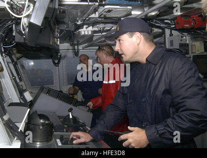 040819-C-7293M-001 à bord du garde-côte de Galveston Island (GTPP) 1349 - 19 août 2004 - Lieutenant Jerome E. Dubaï, Commandant de la faucheuse Galveston Island, les pairs du pont windows dans un la pluie comme maître de 2e classe Jeremy Demello et Lieutenant, grade junior, Collin MacInnes, Directeur général, discuter des contacts radar de la faucheuse a été reçu. Le Galveston Island, qui est déployée à l'avant du territoire américain de Guam, a été sur station d'escorter l'USS Kitty Hawk (CV 63) à Guam's Apra Harbour pour un port à la suite d'appels d'exercices en groupe de combat. U.S. Banque D'Images