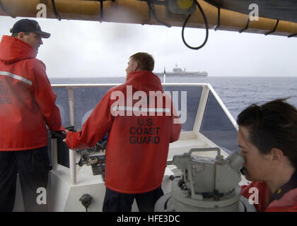 040819-C-7293M-086 à bord du garde-côte de Galveston Island (GTPP) 1349 - 19 août 2004 - Lieutenant Jerome E. Dubaï, Commandant de la faucheuse Galveston Island, discute de l'approche du porte-avions USS Kitty Hawk (CV 63) avec le Lieutenant, grade junior, Collin MacInnes, Directeur général, tandis que l'étoile Suzanne Burgett, de la Garde côtière du Département des opérations de la Section des îles Mariannes, prend une observation d'un bateau de pêche au large de la côte du port de la faucheuse. Le Galveston Island, qui est déployée à l'avant du territoire américain de Guam, a été sur station d'escorter l'USS Kitty Hawk (C Banque D'Images