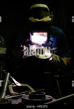 Un technicien de coque de 2e classe soude un coude de tuyau à bord de l'USS Abraham Lincoln (CVN 72) dans le cadre de l'entretien du navire et de la préparation au déploiement. Les travaux sont effectués par la Division de la réparation afin d'assurer l'état de préparation opérationnelle et l'intégrité structurelle du porte-avions. Banque D'Images
