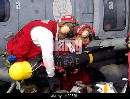 041113-N-0057P-073 de l'océan Pacifique (nov. 13, 2004) - Aviation Ordnanceman affecté à l 'Golden Falcon' de deux hélicoptères de l'Escadron anti-sous-marin (HS-2), charger un missile AGM-114 Hellfire sur un HH-60H Seahawk à bord du porte-avions de classe Nimitz USS ABRAHAM LINCOLN (CVN 72). L'enfer Missile air-sol système offre une forte capacité d'armure pour les hélicoptères d'attaque. Lincoln et entrepris Carrier Air Wing 2 (CVW-2) sont actuellement déployés à l'ouest de l'océan Pacifique. U.S. Navy photo by Photographer's Mate 2e classe Seth C. Peterson (libéré) US Navy 041113-N-0057P-073 Aviation Banque D'Images