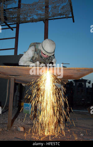 041113-N-5386H-050 Al Anbar Province, l'Iraq (nov. 13, 2004) Ð Métallurgiste 1re classe Joseph Perrott, affectés à la construction navale Bataillon Mobile deux trois (NMCB) 23, coupe de l'acier utilisé pour renforcer le blindage des véhicules tactiques. Perrott et ses collègues ont travaillé Seabees sous menace de tirs hostiles à des dizaines de véhicules blindés de combat et des opérations de patrouille dans les villes de Fallouja et Ramadi, en Irak. U.S. Navy photo by PhotographerÕs Mate 2e classe Michael D. Heckman (libéré) US Navy 041113-N-5386H-050 métallurgiste 1re classe Joseph Perrott, affectés à la construction navale Bataillon Mobile deux trois (N Banque D'Images