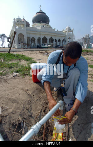 050309-N-8629M-019 Banda Aceh, Sumatra, Indonésie (Mar. 9, 2005) - Hôpital Corpsman 3 classe Ron Berard, affecté à l'unité de médecine préventive de l'environnement Marine Six (NEPMU-6), prend un échantillon d'eau dans un camp de personnes déplacées de la région de Banda Aceh, en Indonésie. Maître de Berard prend des échantillons d'eau pour contrôler la maladie et d'impuretés dans l'eau. NEPMU-6 est actuellement à Banda Aceh sur l'île de Sumatra, Indonésie, et mène des activités quotidiennes afin d'évaluer les problèmes de santé comme l'eau, l'étude des sols, et des maladies et de la lutte contre les vecteurs dans des camps du personnel. Banque D'Images