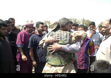 030328-A-2018L-008 Umm Qasr, l'Irak (mars 28, 2003) -- un membre de la libre les forces iraquiennes (FIF) est réunie avec les membres de la famille dans son village. Gratuitement les forces iraquiennes sont Shiia et Sunnites, arabes et kurdes, tous les exilés de l'Iraq qui sont attachés à la démocratie et à assurer la paix dans leur patrie. Les soldats portent l'uniforme de combat avec ÒFIFÓ les correctifs sur l'épaule et aider les États-Unis et les forces de la coalition dans les opérations civiles et militaires. Ce soldat FIF est un citoyen américain qui se sont portés volontaires pour aider la Coalition pour libérer l'Irak et n'a pas vu sa famille depuis plus de dix ans. L'Armée américaine photo c Banque D'Images