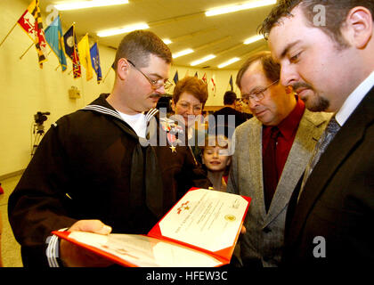 040223-N-5576W-005 base navale de la région des Grands Lacs, en Illinois (fév. 23, 2004) - Hôpital Corpsman 2e classe Alan Dementer de Gladstone, Mich., montre sa famille son certificat Étoile de bronze à la suite de la cérémonie de remise des prix organisée à bord d'Ecole de l'hôpital naval, Grands Lacs, Ill. Dementer, qui est maintenant sur le personnel de l'hôpital à l'École du Corps des Grands Lacs, a reçu le prix de l'Étoile de bronze pour des actions le 26 mars 2003, date à laquelle il a été critiqué dans un Nasariyah, tandis que l'Iraq attribué à deuxième bataillon, 8ème Marines, Task Force Tarawa, Marine Expeditionary Force. Sous le feu et blessé par des éclats, Dementer procé Banque D'Images