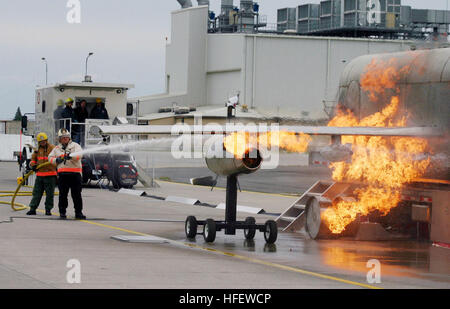 040303-N-5821W-002 Naval Air Station (RNA) de Sigonella, en Sicile (Mar. 3, 2004) - Aviation maître de Manœuvre 1re classe Stephen Mark, NAS Sigonella Fire Department assistant agent de formation, et Ron Hall, NAS Sigonella Fire Department Chef de bataillon, bataille un feu alors que la formation avec l'un aéronef mobile Fire Trainer (MAFT) sur les stations la ligne de vol. Le service d'incendie de NAS a récemment obtenu le système pour améliorer le système de formation. Le MAFT peut simuler des incendies de moteur de roue, les incendies, les feux de l'intérieur, et des éclatements de pneumatiques. Sigonella NAS fournit un soutien logistique aux sixième Commandant de flotte et les forces de l'OTAN Banque D'Images