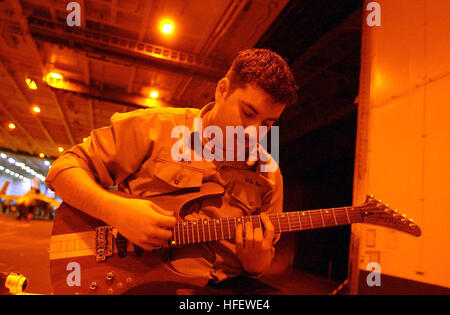 040304-N-5945J-003 à bord du USS Harry S. Truman (CVN75). Personelman Seaman Apprentice David Smith joue de la guitare dans la baie de suspension pour trois des loisirs. L'USS Harry S. Truman est actuellement en cours de vol et des qualifications de l'opérateur de certification de pont au large de la côte atlantique. Photographer's Mate Airman Bridgette Jenkins (U.S. Photo par Marine : Photographer's Mate Airman Bridgette Jenkins. Publié par TVH Affaires publiques.) US Navy 040304-N-5945J-003 au cours d'une pause à partir de ses fonctions en mer, Personnelman Seaman Apprentice David Smith joue de la guitare dans le navire  % %5Ersquo,s hangar Bay à bord du personnel navigant Banque D'Images