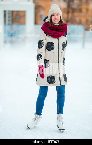 Happy young girl patinage sur une patinoire en plein air Banque D'Images