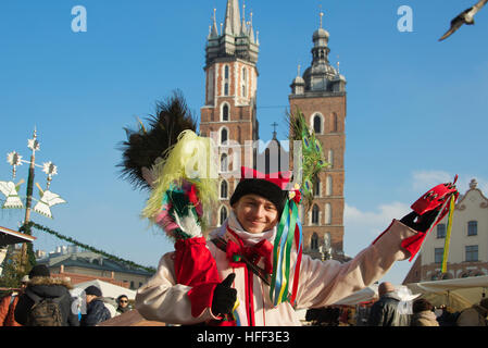 Homme habillé en costume coloré avec l'église St Mary Place du Marché Krakow Pologne Banque D'Images