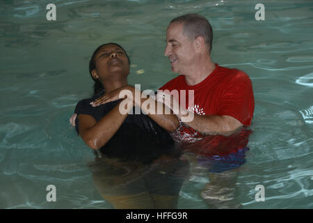 Un prédicateur baptise une femme au cours d'une cérémonie de baptême Banque D'Images