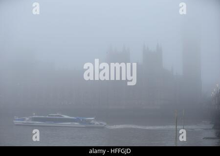 Une enveloppe de brouillard Thames Clipper passant les chambres du Parlement, au centre de Londres après avoir averti les prévisionnistes de visibilité aussi bas que 100 mètres avec du brouillard et des températures sous zéro à travers de vastes étendues de l'Angleterre. Banque D'Images