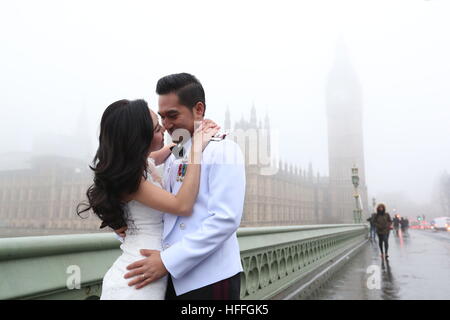 Un couple thaïlandais poser pour leurs photos avant-mariage, l'avenir de leur mariage en juillet, le brouillard enveloppe la chambres du Parlement dans le centre de Londres après avoir averti les prévisionnistes de visibilité aussi bas que 100 mètres avec du brouillard et des températures sous zéro à travers de vastes étendues de l'Angleterre. Banque D'Images