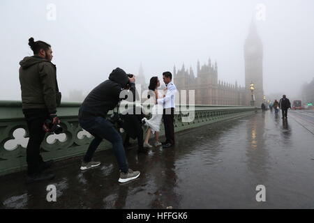 Un couple thaïlandais poser pour leurs photos avant-mariage, l'avenir de leur mariage en juillet, le brouillard enveloppe la chambres du Parlement dans le centre de Londres après avoir averti les prévisionnistes de visibilité aussi bas que 100 mètres avec du brouillard et des températures sous zéro à travers de vastes étendues de l'Angleterre. Banque D'Images