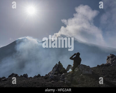 Le randonneur regardant deux cratères fumants, à l'est en rétro-éclairage, voir à partir de la Rocca della Valle lookout point, le Mont Etna, le volcan Banque D'Images