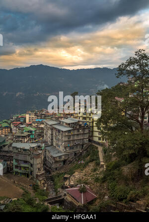 Coucher de soleil sur la ville de l'Himalaya de Gangtok, avec des montagnes au loin du ciel et des bâtiments. Le Sikkim, Inde. Banque D'Images