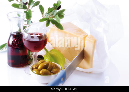 Vin et fromage collation : carafe et verre de vin rouge, bol d'olives vertes, le fromage parmesan Banque D'Images