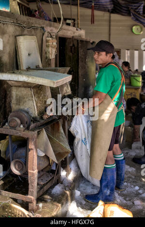 Fabrication de glace. Les travailleurs qui utilisent des machines pour fabriquer de la glace concassée pour la conservation des aliments sur le marché local du poisson. Thaïlande S. E. Asie Banque D'Images