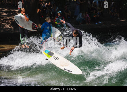 Surfer fait un saut sur l'onde stationnaire dans l'artificiel dans l'Eisbach Englisher Garten de Munich, Allemagne. Banque D'Images