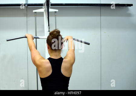 Lat pulldown dans la salle de sport. Woman working out ses muscles du dos et des bras. Banque D'Images