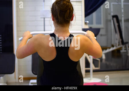 Woman working out ses muscles du dos et des bras avec la poulie à la salle de sport. Banque D'Images