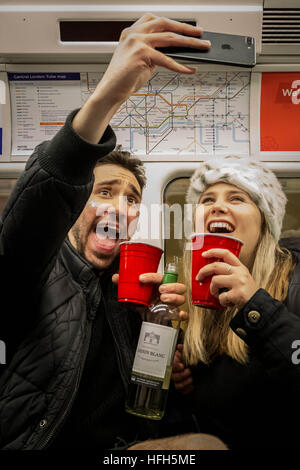 Londres, Royaume-Uni. 1er janvier 2017. La veille du Nouvel An : un joyeux couple prendre une photo selfies sur la ligne Jubilee line © Guy Josse/Alamy Live News Banque D'Images