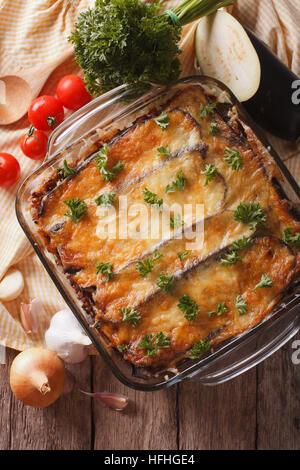 Moussaka grecque close up dans le plat de cuisson avec les ingrédients sur la table. vertical vue d'en haut Banque D'Images