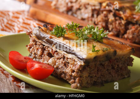 Partie de la moussaka aux aubergines sur une plaque horizontale verte macro. Banque D'Images