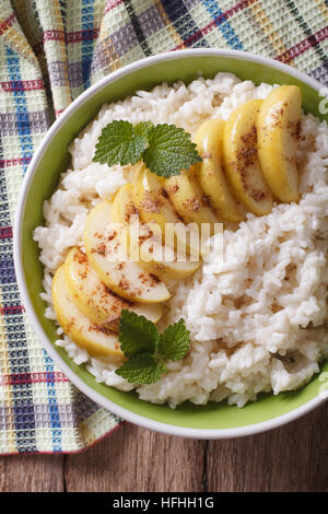 Riz aux pommes caramélisées Dans un bol sur une table close-up vertical Vue de dessus. Banque D'Images