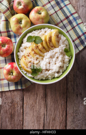 Riz aux pommes caramélisées Dans un bol et les pommes fraîches sur une table verticale Vue de dessus. Banque D'Images