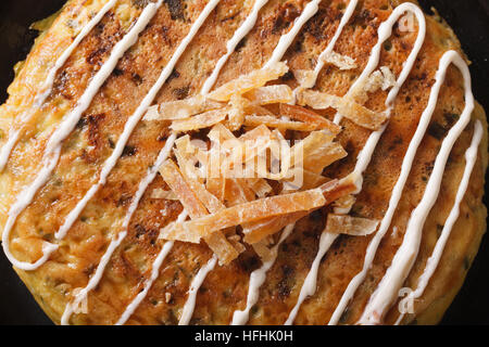 La nourriture japonaise : okonomiyaki sur une plaque horizontale. macro vue du dessus Banque D'Images