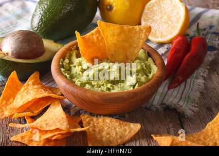 Sauce guacamole nachos et de maïs et les ingrédients sur la table. Rustique, horizontale Banque D'Images