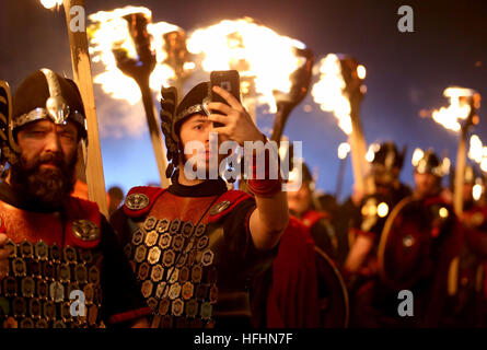 L'un des Shetlands Up Helly AA Vikings prend un selfie lors de l'événement d'ouverture des célébrations d'Edinburghs Hogmanay, la procession annuelle de Torchlight,Alors que des milliers de porteurs de flambeaux dirigés par les Vikings modernes et les tuyaux et tambours massés défilent dans le centre-ville jusqu'à un feu d'artifice spectaculaire finale avant les célébrations de Hogmanay pour le nouvel an. Banque D'Images