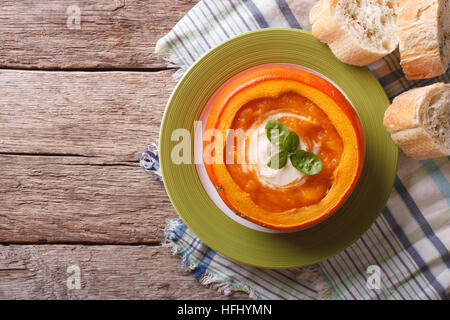 La soupe en purée avec de la crème et basilic dans une citrouille cuite horizontale Vue de dessus. Banque D'Images