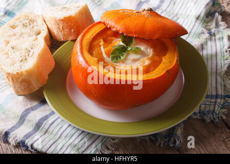 Soupe de purée diététique avec de la crème et le basilic dans un potiron close up horizontal. Banque D'Images