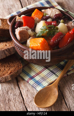 Eintopf soupe riche avec de la viande, des saucisses et des légumes sur la table. La verticale Banque D'Images