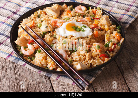 Riz frit avec du poulet asiatique, les crevettes, les œufs et les légumes close-up l'horizontale Banque D'Images