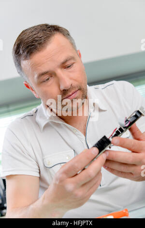 Man looking at composant électrique Banque D'Images