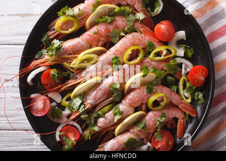 Crevettes géantes au piment, des herbes et des légumes close-up dans une casserole. Vue du dessus horizontale Banque D'Images