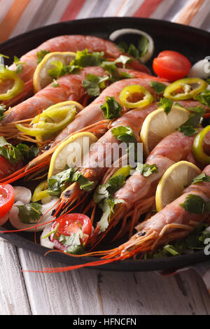 Crevettes géantes avec le citron, les herbes et les légumes sur une assiette. La verticale Banque D'Images