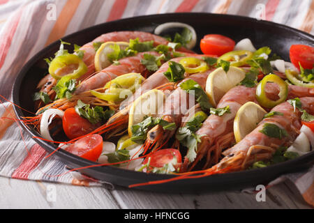 Crevettes géantes avec le citron, les herbes et les légumes sur une plaque horizontale. Banque D'Images