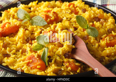 Pilaf sucré avec des raisins secs et des abricots séchés close-up sur une plaque horizontale. Banque D'Images