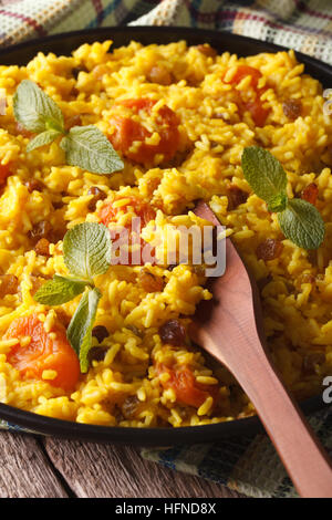 Riz aux raisins et abricots secs close-up sur une plaque verticale. Banque D'Images