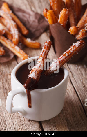 Churros espagnol avec une tasse de chocolat chaud sur une table verticale. Banque D'Images