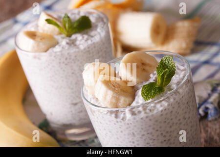 Petit-déjeuner sain : yaourt avec les graines de chia et de la banane dans un verre macro. L'horizontale Banque D'Images