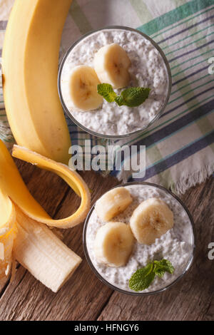 Les graines de chia pudding à la banane et dans un verre sur la table. vertical vue d'en haut Banque D'Images