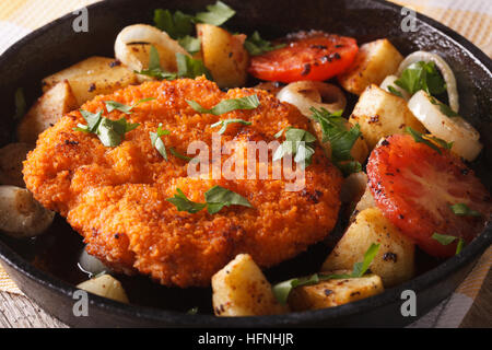 Schnitzel avec légumes frits dans une casserole sur la table horizontale. Banque D'Images
