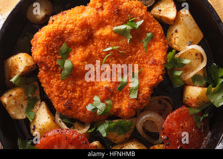 Weiner schnitzel pané allemand, les pommes dans une casserole close-up Vue de dessus horizontale. Banque D'Images