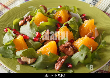 Salade fraîche à la grenade, l'orange et à la roquette sur une plaque horizontale. Banque D'Images